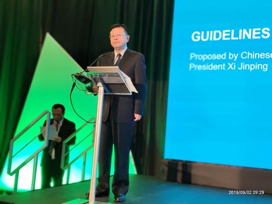 A person standing in front of a screen
Description automatically generated